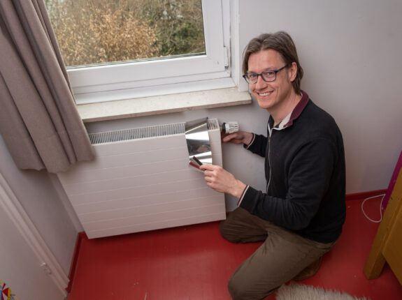 Marco Jeurissen plaatst radiatorfolie op radiator