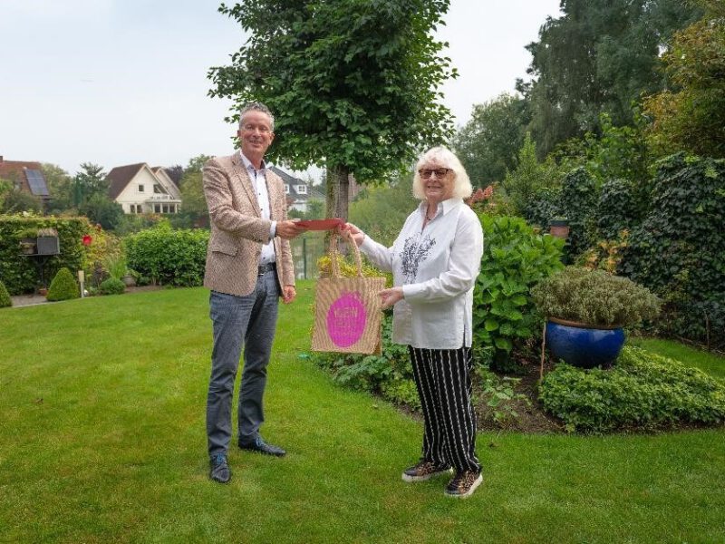 Wethouder Jan Smits overhandigt een prijs aan de winnares