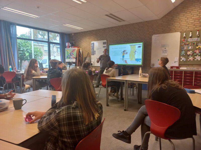 Kinderen in klas die luisteren naar een gastles over energiebesparing